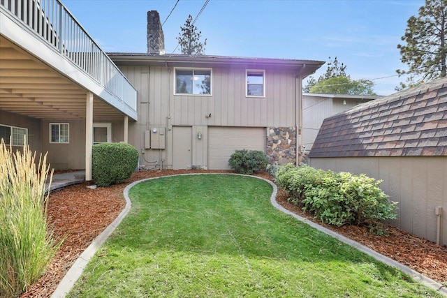 rear view of house with a yard and a garage