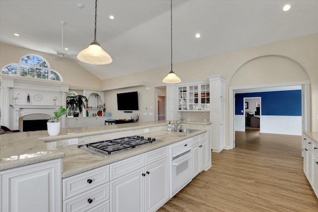 kitchen with hanging light fixtures, light hardwood / wood-style floors, and white cabinets