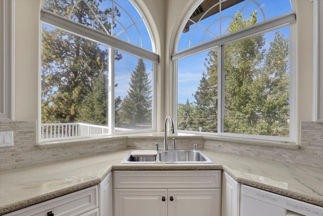 kitchen featuring white cabinets, white dishwasher, sink, and a healthy amount of sunlight