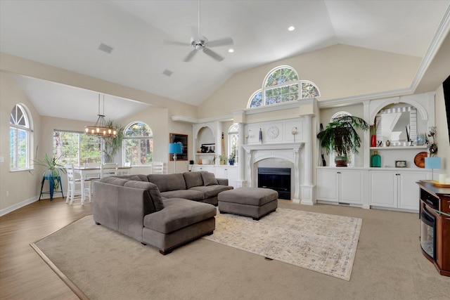 living room with ceiling fan with notable chandelier, light wood-type flooring, and lofted ceiling