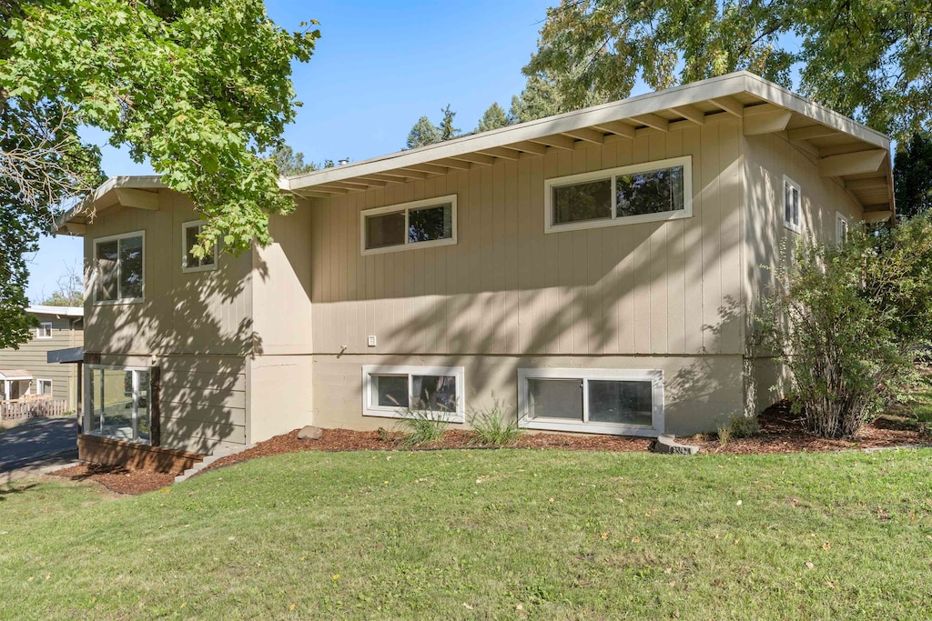 rear view of property featuring a lawn