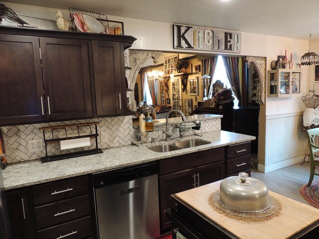 kitchen featuring dark brown cabinets, light stone counters, sink, and stainless steel dishwasher