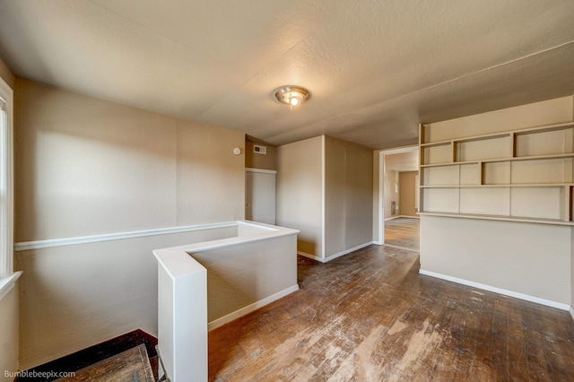 unfurnished room featuring dark hardwood / wood-style floors and a textured ceiling