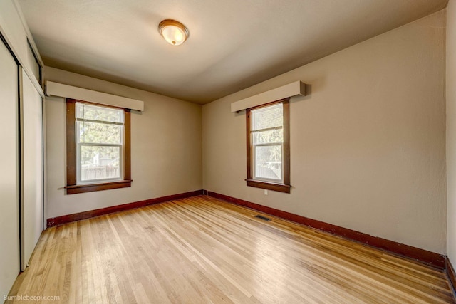 spare room featuring plenty of natural light and light hardwood / wood-style floors