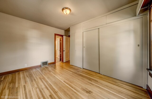 unfurnished bedroom featuring a closet and light hardwood / wood-style floors