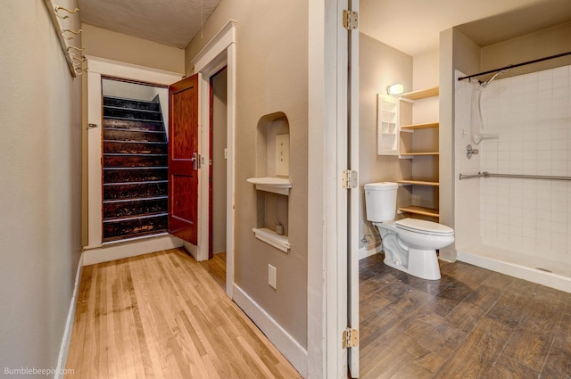 bathroom with walk in shower, hardwood / wood-style flooring, and toilet