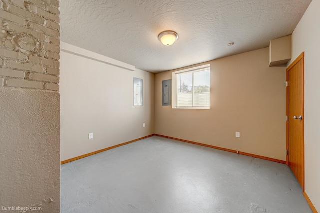 empty room with concrete floors, electric panel, and a textured ceiling