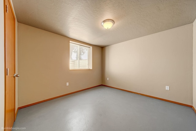 spare room with concrete flooring and a textured ceiling