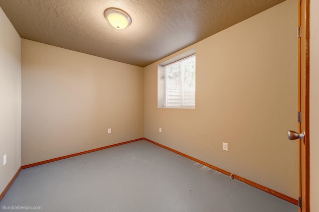 unfurnished room featuring a textured ceiling and concrete floors