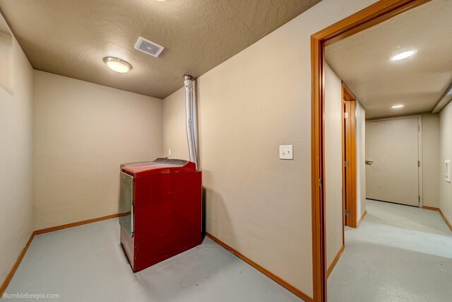 laundry area featuring washer / clothes dryer and a textured ceiling