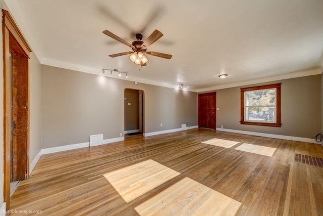 empty room with track lighting, light wood-type flooring, and ceiling fan