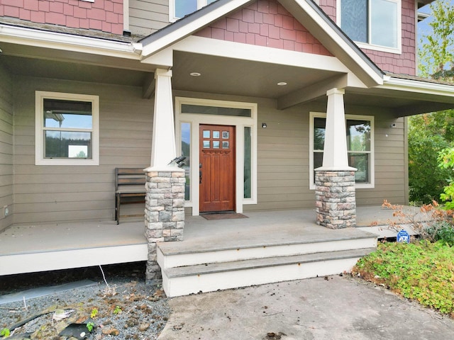 view of exterior entry featuring covered porch