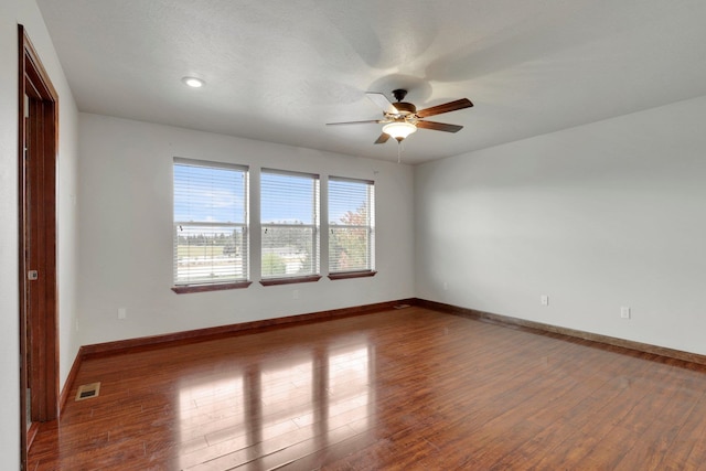 empty room featuring ceiling fan, hardwood / wood-style flooring, and a textured ceiling