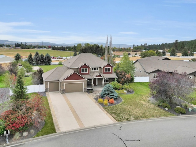 view of front of home with a garage, a front lawn, and a mountain view