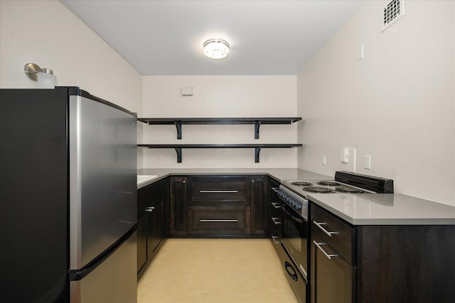 kitchen featuring dark brown cabinetry, stainless steel fridge, black range oven, and light carpet