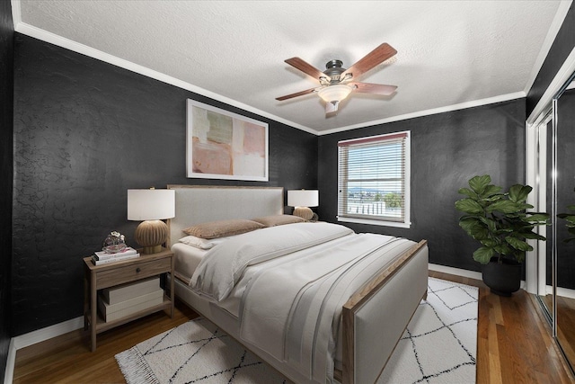 bedroom featuring wood-type flooring, crown molding, a textured ceiling, and ceiling fan