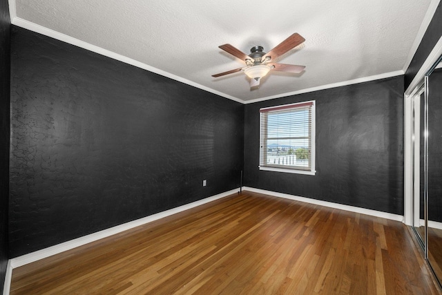 empty room featuring crown molding, hardwood / wood-style flooring, a textured ceiling, and ceiling fan