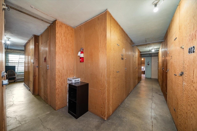 hall with wooden walls and concrete floors