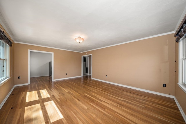 empty room featuring crown molding and light hardwood / wood-style floors