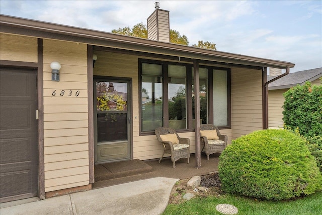 view of exterior entry featuring covered porch and a garage