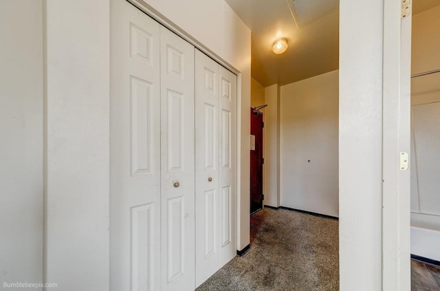 hall featuring dark colored carpet