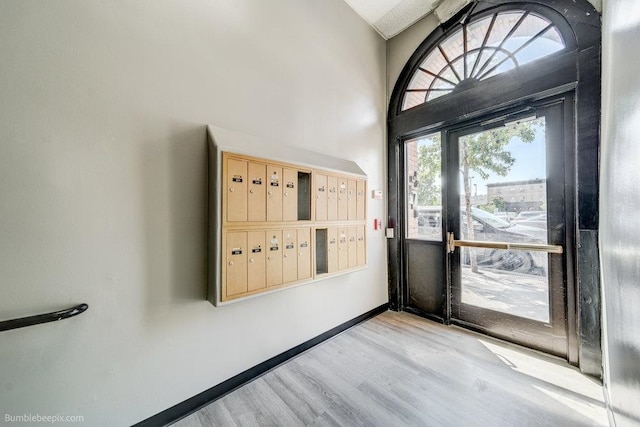 foyer entrance with light wood-type flooring and mail boxes