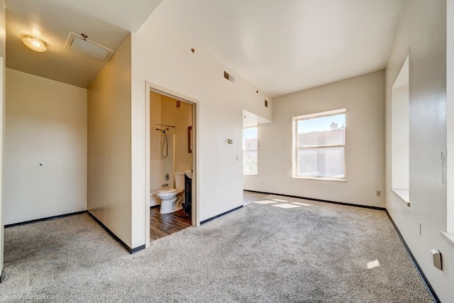 unfurnished bedroom with ensuite bathroom and light carpet