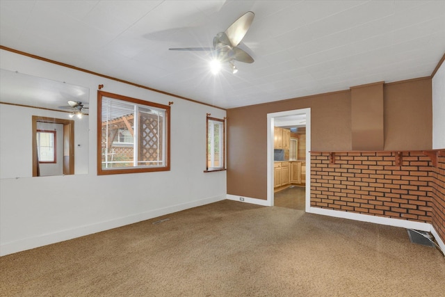 spare room featuring crown molding, carpet, and ceiling fan