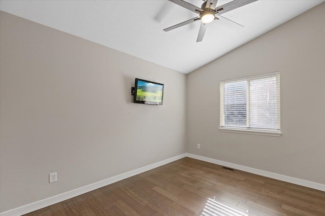 empty room with lofted ceiling, hardwood / wood-style floors, and ceiling fan