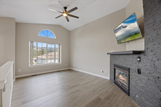 unfurnished living room featuring ceiling fan, light hardwood / wood-style flooring, a fireplace, and lofted ceiling