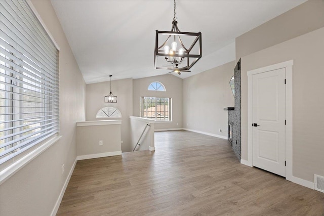 interior space with hardwood / wood-style floors, a notable chandelier, and vaulted ceiling