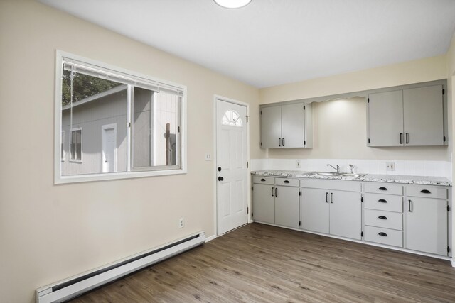 kitchen with white appliances, a baseboard heating unit, sink, gray cabinets, and dark hardwood / wood-style flooring