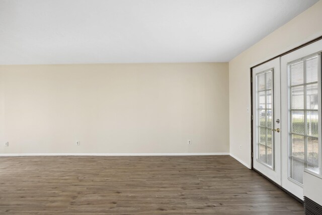 unfurnished living room with baseboard heating, dark hardwood / wood-style flooring, french doors, and heating unit