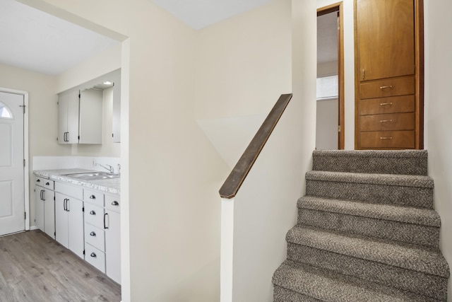 stairway with wood-type flooring and sink