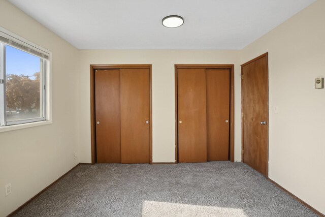 unfurnished room with carpet and baseboard heating