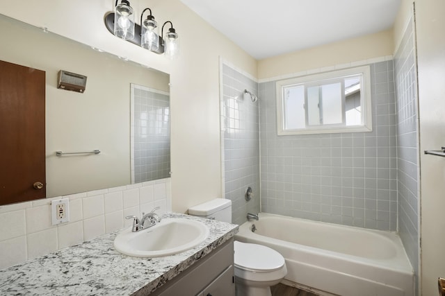 full bathroom with tiled shower / bath combo, toilet, backsplash, and vanity