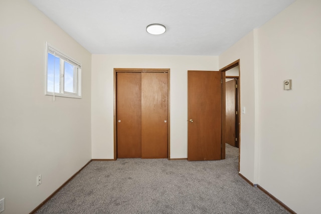 unfurnished bedroom featuring light carpet and a closet