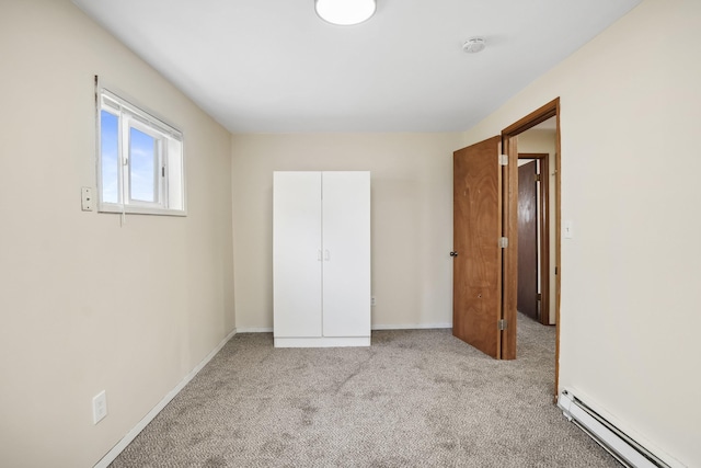 unfurnished bedroom with light colored carpet and baseboard heating