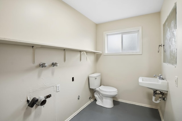 bathroom with concrete floors and toilet