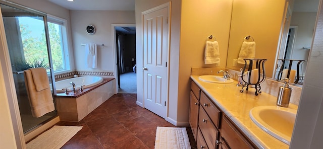 bathroom featuring vanity, a relaxing tiled tub, and tile patterned floors