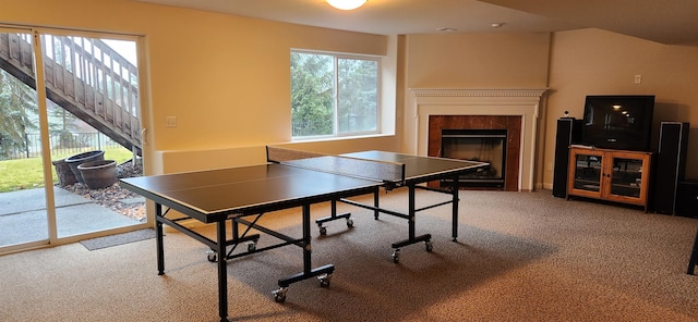 recreation room featuring carpet and a tile fireplace