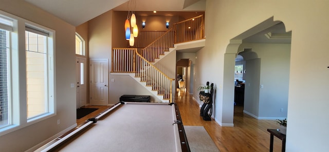 exercise room featuring plenty of natural light, light hardwood / wood-style floors, and a high ceiling