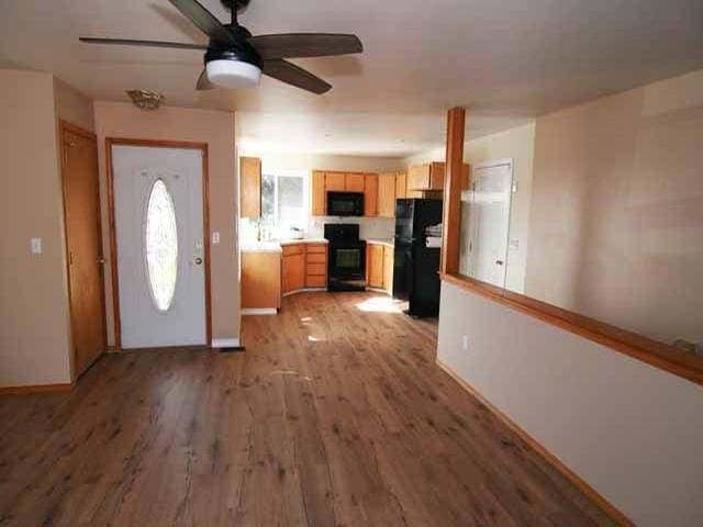 kitchen with ceiling fan, light brown cabinetry, light hardwood / wood-style flooring, and black appliances