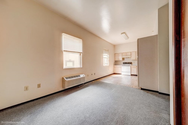 unfurnished living room featuring light colored carpet and an AC wall unit