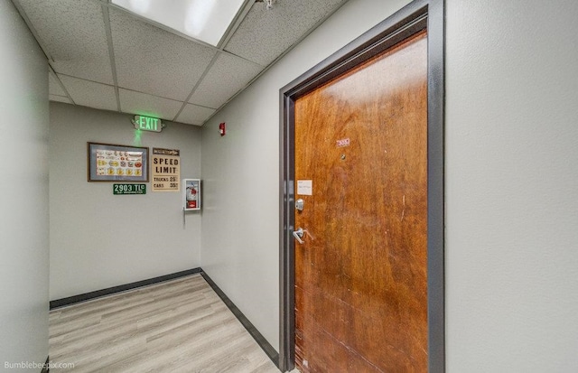 interior space with a drop ceiling and hardwood / wood-style floors