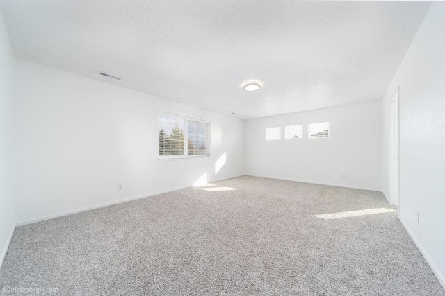 carpeted spare room with a textured ceiling