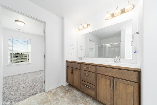 bathroom featuring a shower with door and vanity