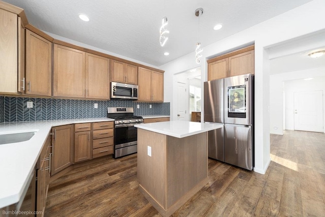 kitchen featuring a kitchen island, dark wood-type flooring, decorative light fixtures, appliances with stainless steel finishes, and tasteful backsplash