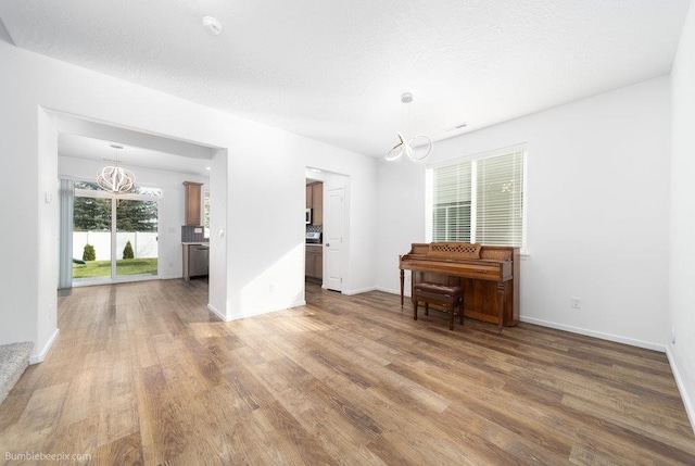 interior space with a notable chandelier, hardwood / wood-style floors, and a textured ceiling