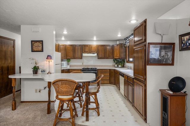 kitchen with black electric range oven, dishwasher, a kitchen breakfast bar, kitchen peninsula, and white fridge